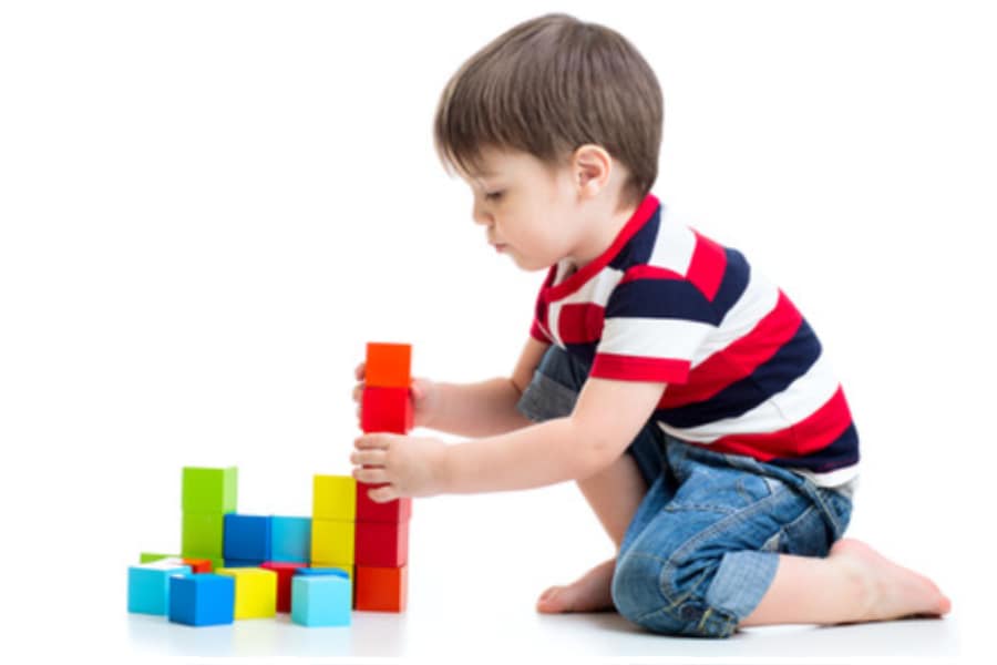 toddler playing with non-toxic wooden blocks